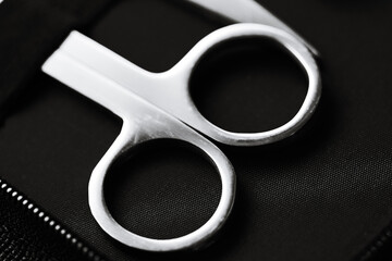 Poster - A pair of scissors sits atop a black bag, ready for use.