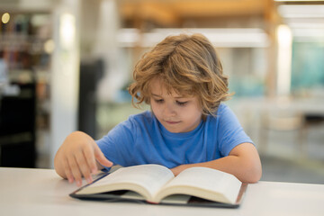 Kid reading book. Child reading book in a public library. Kids early learning and education concept.