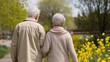 © K-MookPan - An elderly couple walking hand in hand through a beautiful garden filled with blooming flowers, enjoying a peaceful moment together.