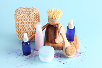 Wall Mural - Set of massage brushes with bath sponge and cosmetic products on blue background