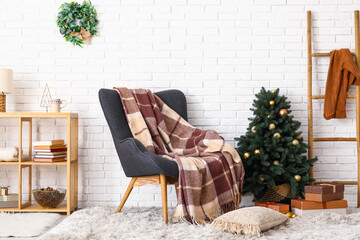 Interior of living room with armchair and Christmas tree