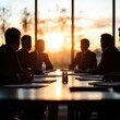 © Tonton54 - Silhouetted business meeting at sunset in a modern office setting.