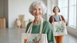 © ryker - Elderly women smiling while holding fabric tote bags with floral designs, showcasing their creativity and joy in bright, spacious environment