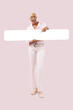 © amedeoemaja - Smiling African woman showing white blank banner, isolated on pink background. Advertising commercial sign. Store and mall Billboard top deals or Black Friday sale and offer or online shopping