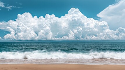 Scenic view of ocean waves and fluffy clouds under bright blue sky.