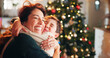 © Flashizzle/peopleimages.com - Christmas, house and hug with mama, son and bonding together with love, decoration and mother in lounge. Xmas tree, family and parent with boy, embrace and care with happiness, holiday and festive