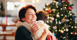 © Flashizzle/peopleimages.com - Christmas, house and hug with mother, son and bonding together with gift, decoration and care in lounge. Xmas tree, family and parent with boy, embrace and present with happiness, holiday and festive