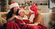 © Flashizzle/peopleimages.com - Christmas, family and laugh on sofa with book, funny storytelling and joking together. Parents, child and happy in home with novel, reading humor and excited at festive season with comedy on couch