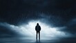 © Petchladda - A person standing under a dark, stormy sky, with rain pouring down, symbolizing gloom and negativity.