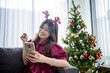 © Odua Images - asian woman feeling excited at christmas day, holding phone