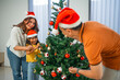 © Odua Images - little family having fun decorating christmas tree together