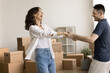 © fizkes - Moving day celebration. Energetic excited millennial spouses relax from unboxing belongings dance twirl in living room at new flat hold hands laugh having fun enjoy starting family life at own house
