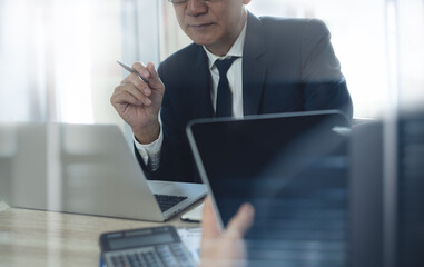 Asian businessman, senior manager working on laptop and his colleague working at office. Business meeting, finding business solution in meeting room, teamwork, corporate business concept