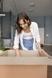 © fizkes - What is inside. Curious smiling young female open big carton box unpack postal parcel delivered by mail check container with consumer goods received from ecommerce store unboxing stuff at moving day