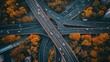 © prastiwi - Aerial view of a busy highway interchange surrounded by autumn foliage.