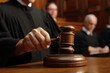 © Denis - Male judge hand holding striking gavel to bang on sounding block in court room, pronounces verdict, close up detail.