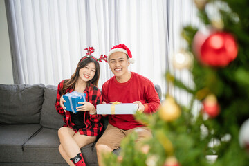 potrait of asian couple exchanging christmas present at home