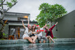 © Odua Images - young people raising toast at christmas pool party, christmas celebration concept