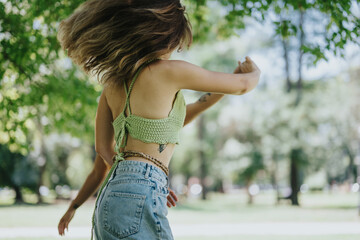 Young adults enjoying a bright sunny day in the park, dancing and having fun together amidst lush greenery