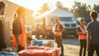 © alisluch - Volunteers distributing emergency supplies to disaster victims, with trucks and tents in the background, illuminated by bright sunlight. Copy space