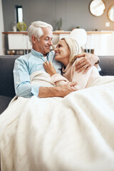 Poster - Blanket, mature couple and smile on sofa in living room of home together for bonding, break or romance. Cozy, cuddle or hugging with happy man and woman in apartment for love, relationship or romance