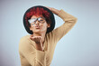 © Sanc/peopleimages.com - Blowing kiss, flirt and portrait of woman in studio with style for emotion, love and emoji reaction. Redhead, glasses and isolated person with confidence, silly and positivity on white background