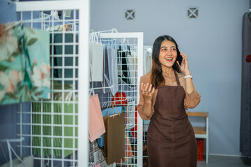 Portrait of a cheerful business owner talking on the phone inside a souvenir shop