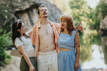 Poster - Three friends are enjoying a sunny day by the river. They are smiling and embracing each other, highlighting friendship and joy in a beautiful natural setting.