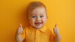 © smth.design - Happy baby giving thumbs up in a vibrant yellow outfit against a matching background
