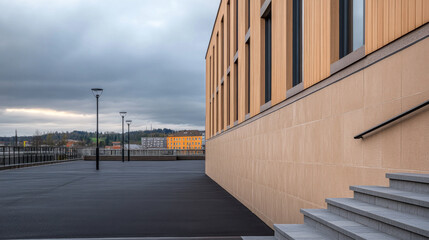 Modern building exterior with steps under cloudy sky in urban setting near waterfront