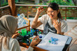 © Odua Images - happy women making an art from plastic bottle cap together