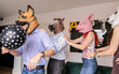 © PintoArt - Friends wearing animal masks celebrating during a house party