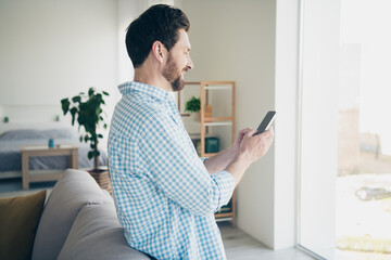 Canvas Print - Photo of handsome bearded alone mature age business man staying home in his new house indoors chatting and looking into huge window