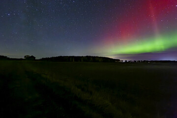 Wall Mural - northern lights dancing over couhtry landscape