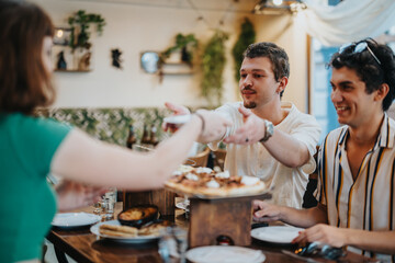 Wall Mural - A group of friends sharing food and laughter at a cozy restaurant, creating a warm and joyful atmosphere with smiles and camaraderie.