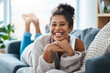 © Sanc/peopleimages.com - Girl, portrait and relax on sofa with smile, comfort and positivity in home living room. Woman, student and happy on couch for study break, stress free and optimistic on weekend in Brazil apartment