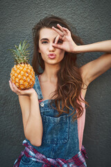 Wall Mural - Girl, portrait and pineapple with funny face outdoor for summer fruit, healthy food and okay gesture for nutrition. Woman, person and hand emoji on gray background with organic diet approval and pout