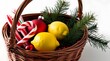 © Chaudhry - A wicker basket filled with various Christmas items, including a red and white striped candy cane, a yellow lemon, a red ornament, and some evergreen branches