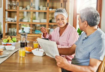 Poster - Newspaper, breakfast and senior couple in house eating healthy, wellness and diet food together. Happy, conversation and elderly man and woman reading headlines and enjoying morning meal in home.