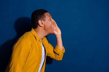 Wall Mural - Photo of young guy in yellow shirt touch cheek announce news black friday start empty space billboard isolated on dark blue color background