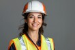 © Alina - Portrait of female worker in helmet and safety vest on grey background