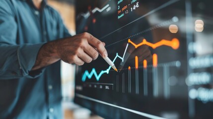 Wall Mural - Businessman analyzing financial graphs on a digital interface. Close-up shot of hands and screen.