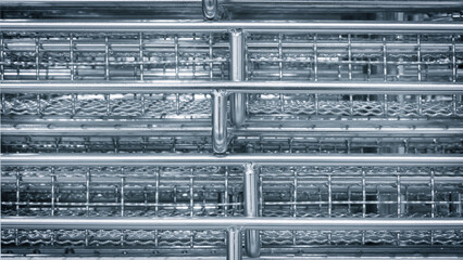 Aufkleber - The image is of a metal structure with a lot of holes in it. The holes are arranged in a grid pattern, and the structure appears to be made of metal. Scene is industrial and utilitarian