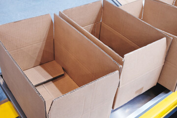 Poster - cardboard boxes are stacked on top of each other. The boxes are empty and have no labels or markings. Concept of organization and efficiency, as the boxes are neatly stacked and ready for use