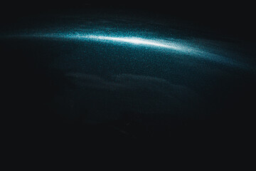 A dark sky with a bright blue streak in the middle. The blue streak is surrounded by a white line