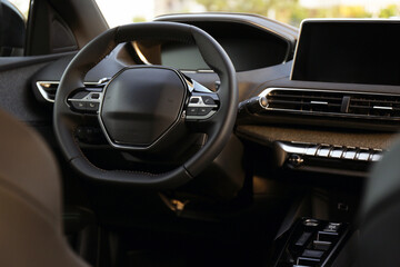 Steering wheel and dashboard inside of modern luxury car, closeup