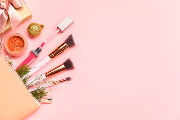 Poster - Different makeup brushes, decorative cosmetics and Christmas decor on pink background, flat lay. Space for text