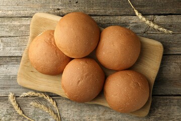 Wall Mural - Fresh tasty buns and spikes on wooden table, top view