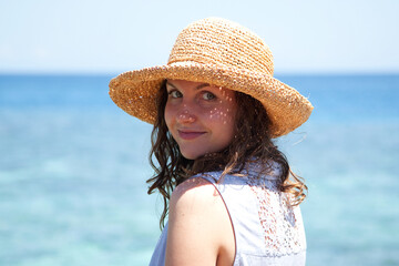 portrait of a young smiling happy woman in a straw hat on a vacation