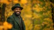 © P - Stylish man in autumn forest wearing green suit and hat with yellow flower accessory